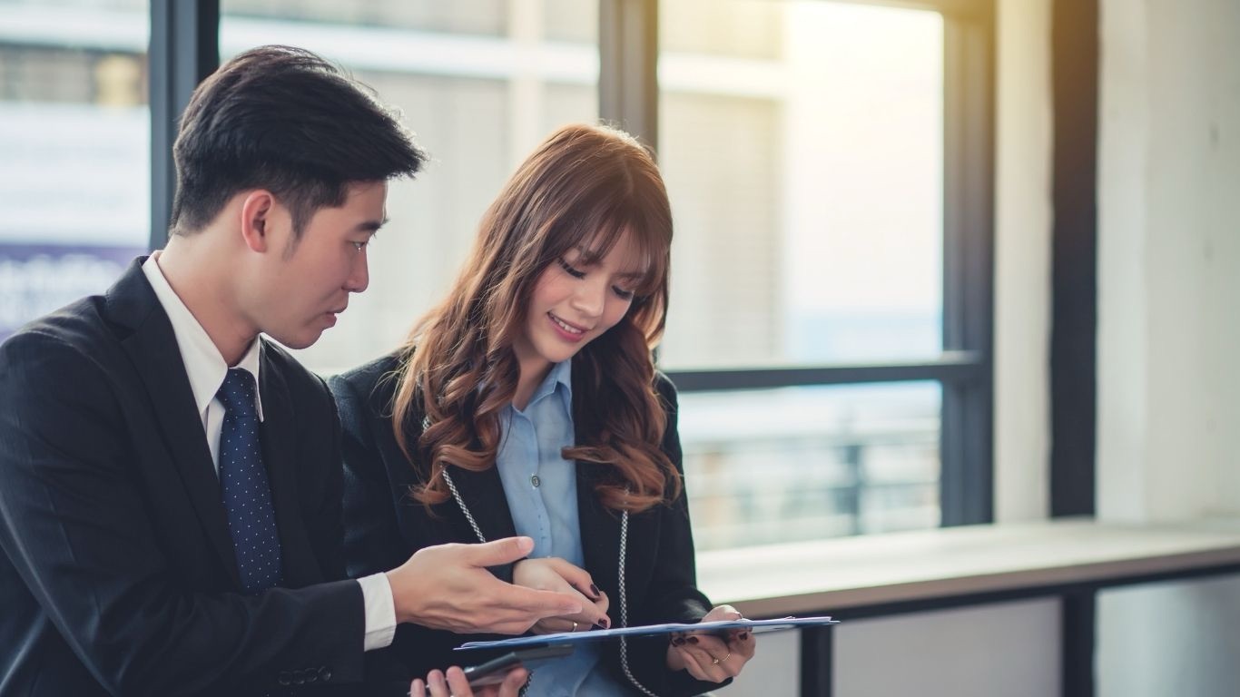 Dua profesional meninjau laporan assessment di tablet